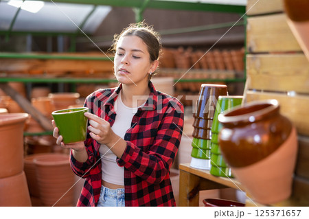 Portrait of woman choosing pots for flowers in gardening market 125371657