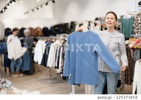 Adult woman choosing coat in store 125371658