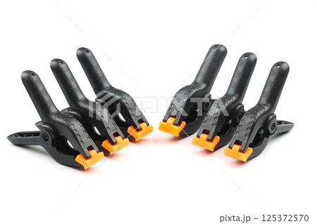 black plastic spring clamp isolated over white background black plastic spring clamp isolated over white background 125372570