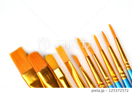 Artistic brushes close up. Watercolor paints in the background. Background with brushes and paints. 125372572