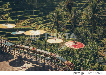 Empty cafe terrace with Balinese umbrellas and view of rice terraces Empty cafe terrace with Balinese umbrellas and view of rice terraces 125372605