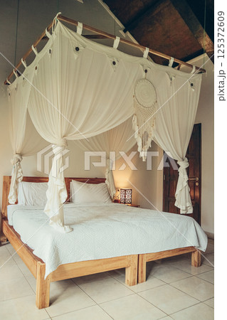 Traditional balinese cozy canopy bed 125372609