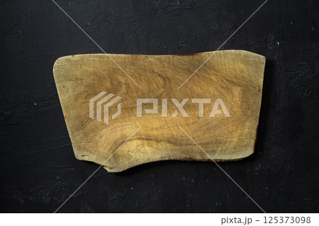 Empty wooden cutting board flat lay on black stone grunge background. Top view Empty wooden cutting board flat lay on black stone grunge background. Top view 125373098