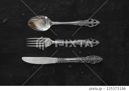 Overhead shot of silverware on black table with copy space. 125373186