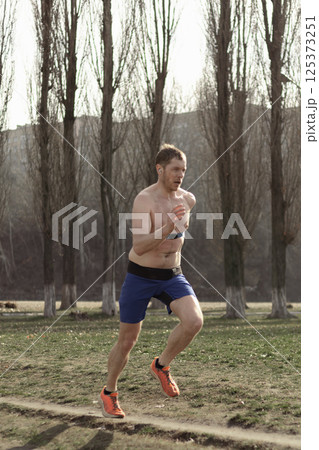 professional runner doing outdoor sports outside the city, sprinting 125373251