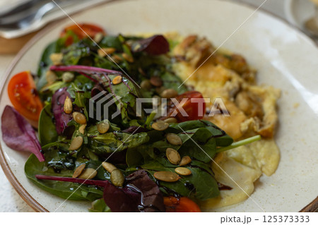 omelet with lettuce, cherry tomatoes and pumpkin seeds omelet with lettuce, cherry tomatoes and pumpkin seeds 125373333