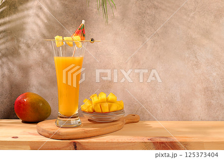 Summer party concept. Homemade cocktail, juice or lemonade with mango slices and ice on sunny kitchen table. Refreshing summer diet drink recipe, Detox diet and healthy lifestyle, Restaurant menu 125373404