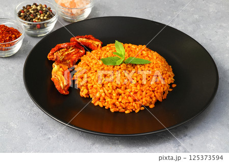 Traditional turkish bulgur pilaf with tomato sause in plate (Turkish name; meyhane pilavi) 125373594