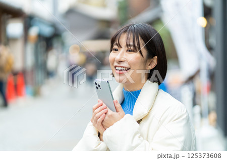 昔ながらの街並みを見る女性　旅行をするコートの女性　一人旅 125373608