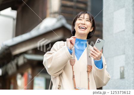 昔ながらの街並みを見る女性 旅行をするコートの女性 一人旅 昔ながらの街並みを見る女性 旅行をするコートの女性 一人旅 125373612