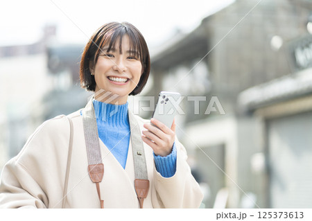 昔ながらの街並みを見る女性　旅行をするコートの女性　一人旅 125373613