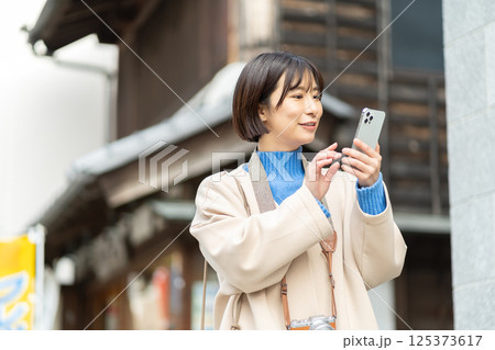 昔ながらの街並みを見る女性 旅行をするコートの女性 一人旅 昔ながらの街並みを見る女性 旅行をするコートの女性 一人旅 125373617