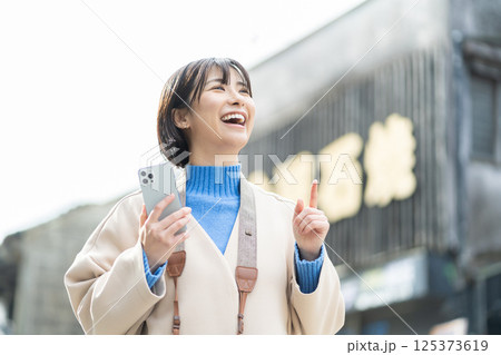 昔ながらの街並みを見る女性　旅行をするコートの女性　一人旅 125373619