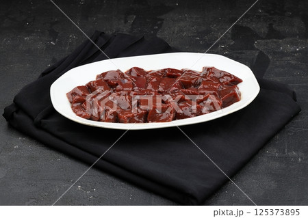 Cut raw beef liver with onions, spices, chili peppers and dill on wooden table, flat lay Cut raw beef liver with onions, spices, chili peppers and dill on wooden table, flat lay 125373895