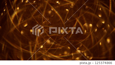 Defocused glittering garland. Bokeh light. Golden celebrate sparkling beautiful yellow colorful flickering circles motion on abstract blurred modern background. 125374866