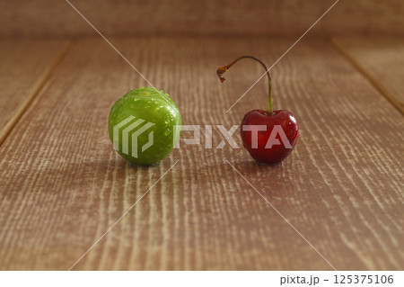 Single whole fresh green Can Erik plum and cherry close up isolated on dark background 125375106