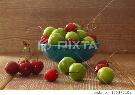 Single whole fresh green Can Erik plum and cherry close up isolated on dark background 125375108