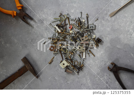 Hammer, wrench, gloves, and other worn and dirty tools on stone background with copy space Hammer, wrench, gloves, and other worn and dirty tools on stone background with copy space 125375355