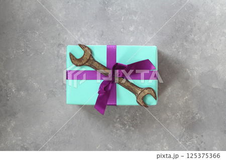 Craft gift with old tool on stone background. Fathers day concept. Flat lay Craft gift with old tool on stone background. Fathers day concept. Flat lay 125375366