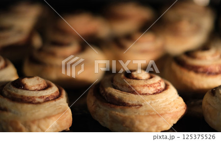 Close-up of freshly baked cinnamon rolls in the oven.  125375526