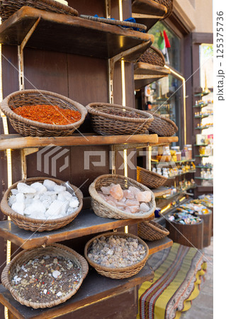 Traditional spices market. Pots and wooden tubs stand in row with colorful tea, spices, fruits, roots, flowers. Street bazaar. Dubai, UAE. Vertical photo Traditional spices market. Pots and wooden tubs stand in row with colorful tea, spices, fruits, roots, flowers. Street bazaar. Dubai, UAE. Vertical photo 125375736