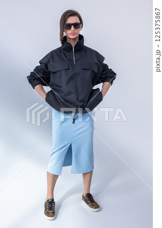 Elegant woman in black windbreaker jacket and light blue skirt on white background. Fashionable female style. Studio photography. Vertical photo. High quality photo Elegant woman in black windbreaker jacket and light blue skirt on white background. Fashionable female style. Studio photography. Vertical photo. High quality photo 125375867