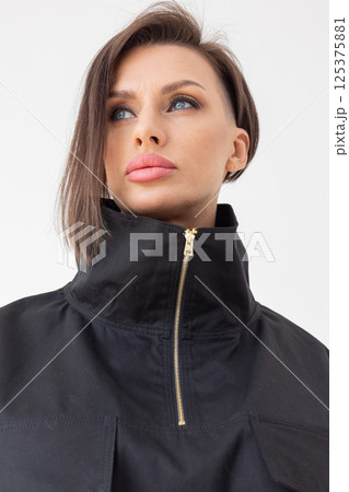 Portrait of beautiful woman in black jacket close-up on white background. Studio photography. Vertical photo. High quality photo 125375881