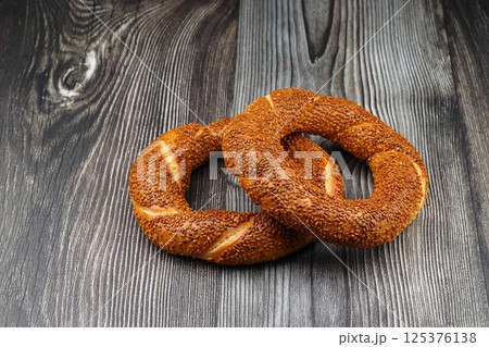 Turkish traditional bagel / simit with sesame on wooden table, turkish breakfast pastry concept Turkish traditional bagel / simit with sesame on wooden table, turkish breakfast pastry concept 125376138