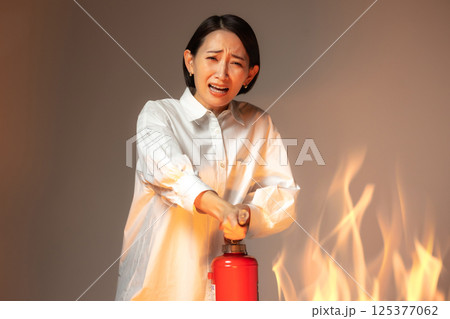女性　火災　消火器 125377062