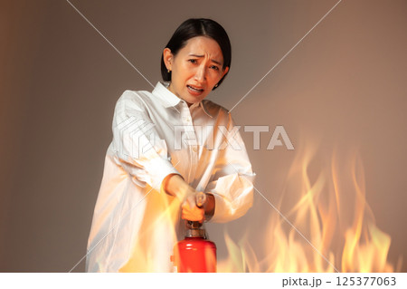 女性　火災　消火器 125377063