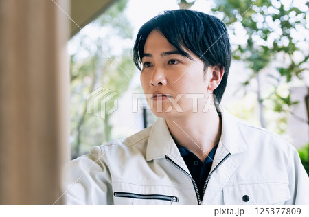 屋外で作業をする作業着の男性 125377809