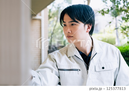 屋外で作業をする作業着の男性 125377813