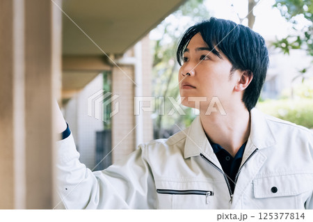 屋外で作業をする作業着の男性 125377814