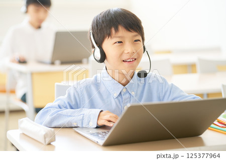 ヘッドセットで学ぶ小学生｜オンラインと教室をつなぐハイブリッド授業 125377964
