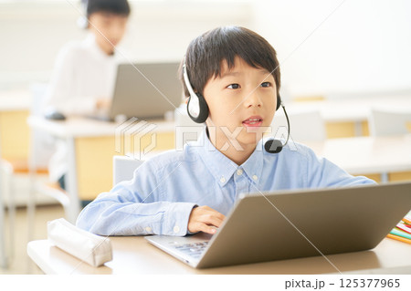 ヘッドセットで学ぶ小学生｜オンラインと教室をつなぐハイブリッド授業 125377965