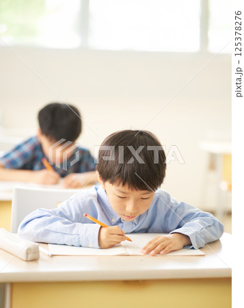 一心に書き込む小学生の男の子|勉強に没頭する真剣な表情 一心に書き込む小学生の男の子|勉強に没頭する真剣な表情 125378276