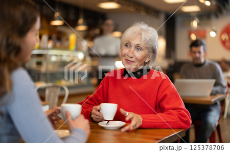 Elderly woman meets her adult daughter in cafe. Conversation over cup of coffee 125378706