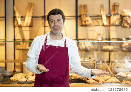 Male baker confidently welcoming customers into his bakery 125378986