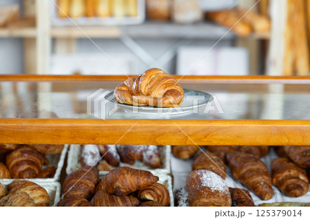 Showcase of traditional bakery shop with appetizing croissants Showcase of traditional bakery shop with appetizing croissants 125379014
