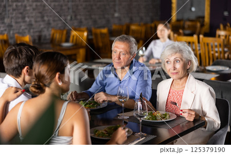 Senior parents enjoying dinner with adult children in restaurant Senior parents enjoying dinner with adult children in restaurant 125379190