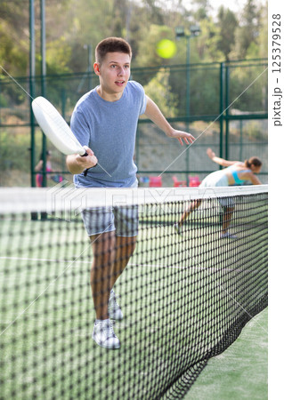 Teenage boy in sportswear playing padel tennis match 125379528
