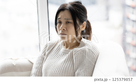 woman feel doubt and sit in the living room woman feel doubt and sit in the living room 125379857