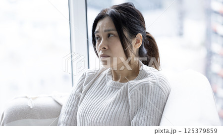 woman feel doubt and sit in the living room woman feel doubt and sit in the living room 125379859