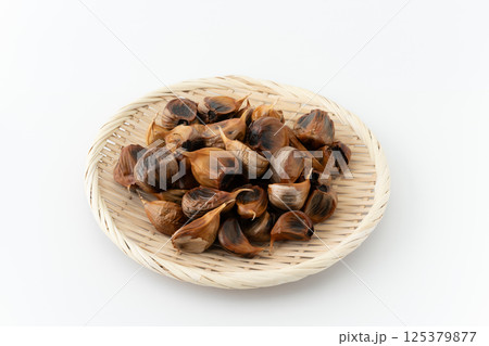 竹ざるに載せた黒にんにく（皮付き） 125379877