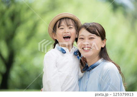 仲良し親子のカメラ目線で夏の子供の暑さ対策　クールリング(ネッククーラー）をつける	 125379913