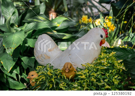 Handmade decorative chicken figure in garden setting. Spring and Easter symbol 125380192