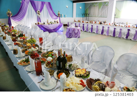 Restaurant with decorated and served tables with food. 125381403