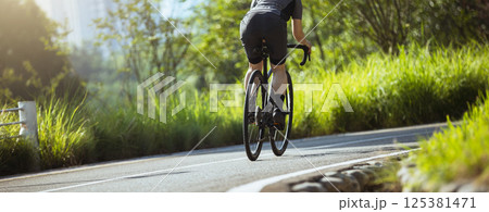 Woman cycling on summer park trail 125381471