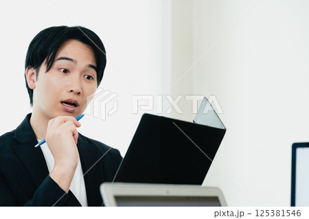 資料を精査するカジュアルスタイルのビジネスマン 125381546