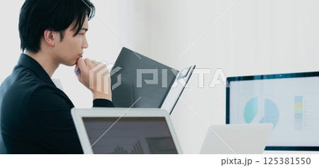 資料を精査するカジュアルスタイルのビジネスマン 資料を精査するカジュアルスタイルのビジネスマン 125381550